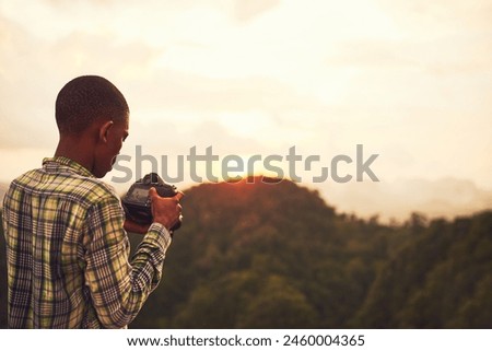 Boy, camera and picture photography on mountain for creative inspiration, travel or sunset. Male person, photo and nature forest for holiday adventure or wilderness environment, safari or journey