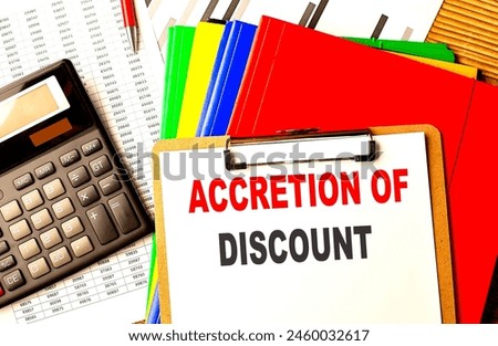 ACCRETION OF DISCOUNT text on clipboard with calculator and color folder 