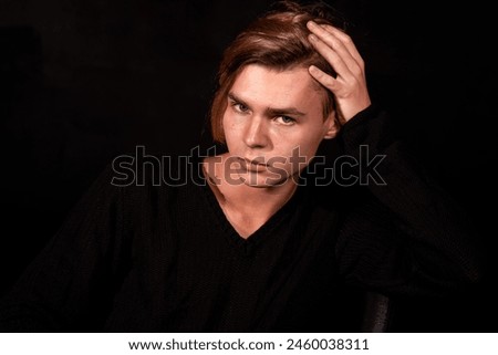 Sad young attractive man relaxing at home.