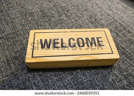 welcome sign in wood on grey background