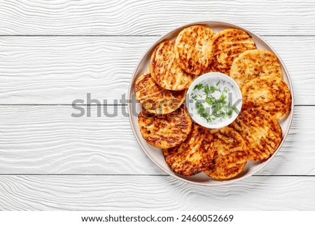 baked in oven high protein savory cottage cheese  parmesan and dill pancakes on plate on white wooden table, horizontal view from above, flat lay, free space