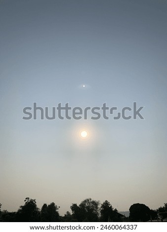 Blurred image of the sun rising in the sky.