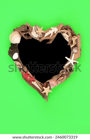 Seashell driftwood heart shape wreath abstract design on green background with chalkboard. Creative natural wood nature sea life composition.