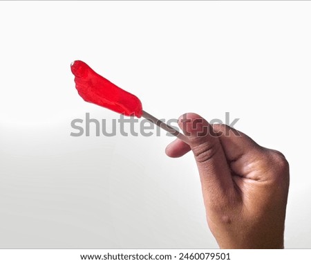 close up of little girl's hand holding a sweet candy cane with white background