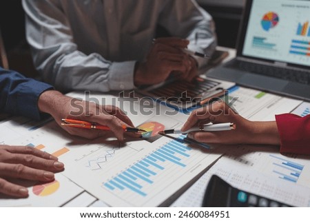 A group of young Asian business colleagues in a team discussion, startup business meeting or team brainstorming ideas analyze and discuss financial report situations.