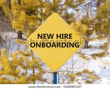 New hire onboarding symbol. Concept words New hire onboarding on beautiful yellow road sign. Beautiful forest snow blue sky background. Business new hire onboarding concept. Copy space.