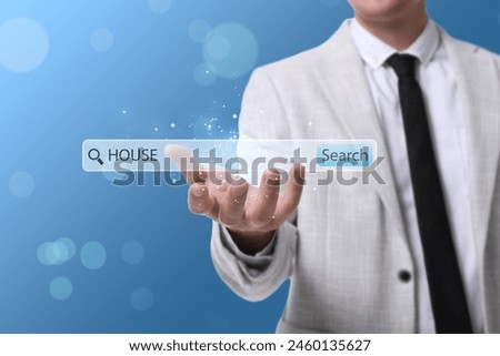 Real estate agent holding virtual search bar with word House on blue background, closeup