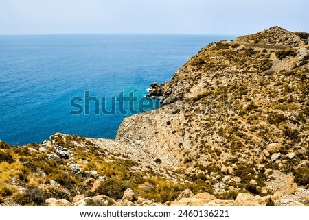 A rocky shoreline with a blue ocean in the background