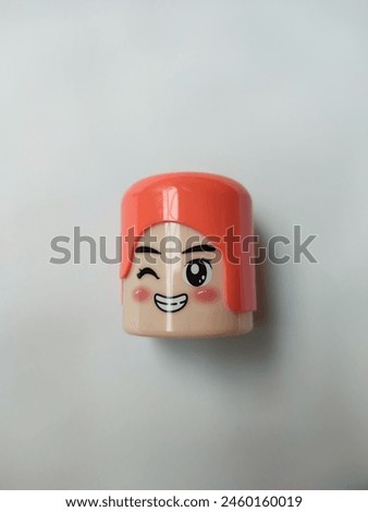 An orange pencil sharpener with a cute character image isolated on a white background