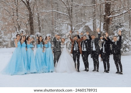A group of people are posing for a picture in the snow, with a bride and groom in the center