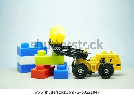 Mini toy of heavy truck and mini figure at table with blurred background. Toy photography concept.
