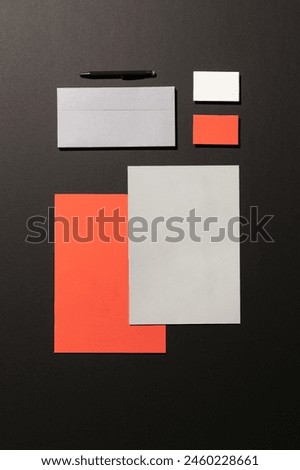 Blank corporate stationery on dark background. Mocks the brand. orange tones
