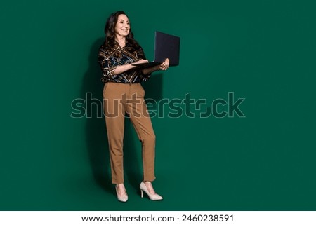 Photo of gorgeous lovely adorable retired lady wear trendy clothes chatting netbook isolated on dark green color background