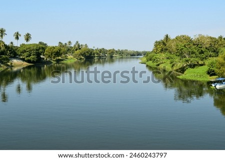 La Antigua river with a green reflection of trees and houses. The water is calm and peaceful Royalty-Free Stock Photo #2460243797