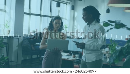 Image of financial data processing over diverse business people using laptop. Global business finance and data processing concept digitally generated image.