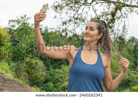 In this captivating stock photo, a cheerful midlife woman, aged 35-39, radiates happiness and contentment as she enjoys the outdoors in a public park during summer.