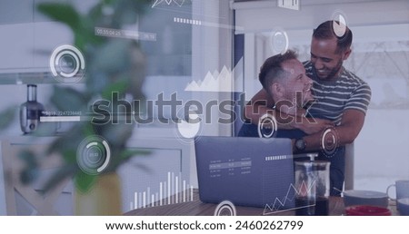 Image of financial data processing over diverse male couple using laptop. Finances, lifestyle and digital interface concept digitally generated image.