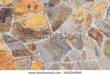 It's photo of mosaic stones in wall. It is close up view of the multicolored stone wall. This is colorful texture for designer. 