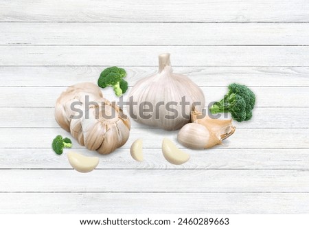 a group of garlic bulbs placed on a wooden surface. Garlic is a root vegetable commonly used as an ingredient in cooking. It is known for its strong flavor and various health benefits.