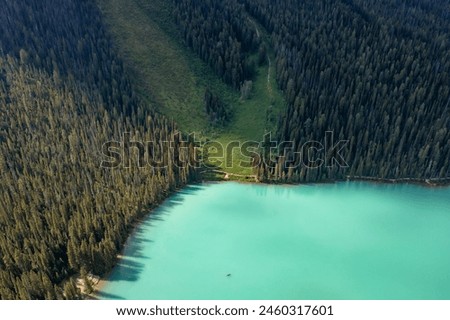 Part of lake in forest that rises into mountains. Canada, Valley of Ten Peaks. Soothing photo.