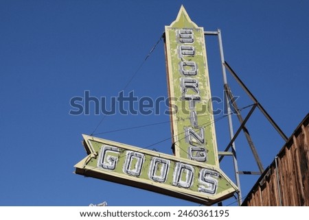 A vintage store sign advertising sporting goods.