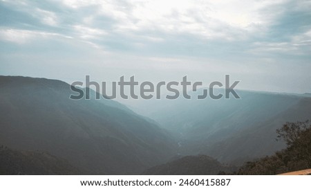 Hill under blanket of clouds and river