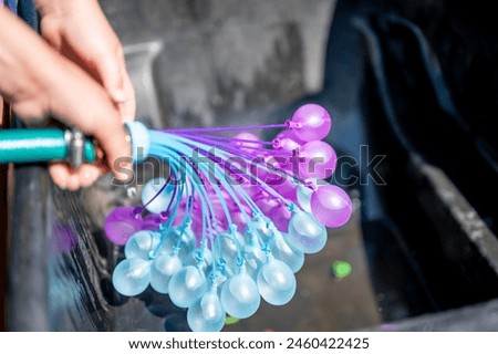 Rapid filling self sealing water balloons being inflated with a hose.