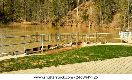 Panorama of the lake and green forest with fir trees in the park in summer in spring. Blue sky. with reflection in water. Park "Red Key" in Russia. Bashkiria. People Walking in the Park
