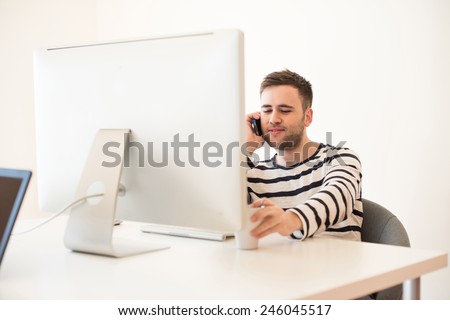 Man working and using mobile phone at the office