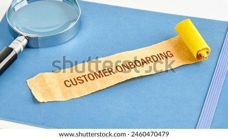 Concept Business. CUSTOMER ONBOARDING symbol on a note made of paper on a blue business notebook