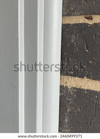 Grey doorframe meets dark brick