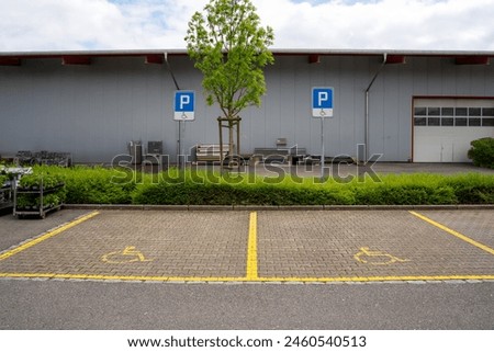 Two parking lots for handicapped people with blue signs to prevent unauthorized parking.