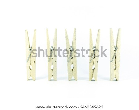 Wooden clothes pins hanging on brown rope isolated on white background
