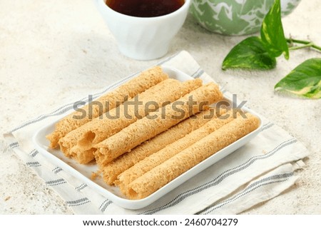 Egg Roll Biscuit or Kue Semprong or sapit, Simping, kue Belanda, or kapit or Love letters in English. It is an Indonesian traditional wafer snack or kuih. Royalty-Free Stock Photo #2460704279