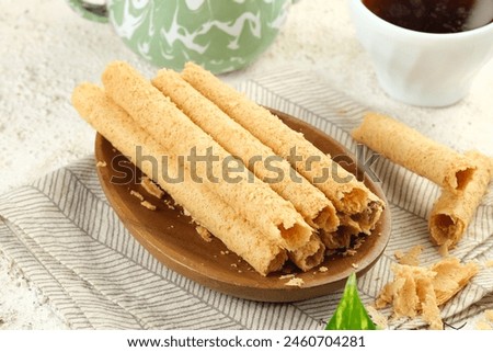 Egg Roll Biscuit or Kue Semprong or sapit, Simping, kue Belanda, or kapit or Love letters in English. It is an Indonesian traditional wafer snack or kuih. Royalty-Free Stock Photo #2460704281