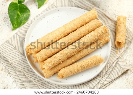 Egg Roll Biscuit or Kue Semprong or sapit, Simping, kue Belanda, or kapit or Love letters in English. It is an Indonesian traditional wafer snack or kuih. Royalty-Free Stock Photo #2460704283
