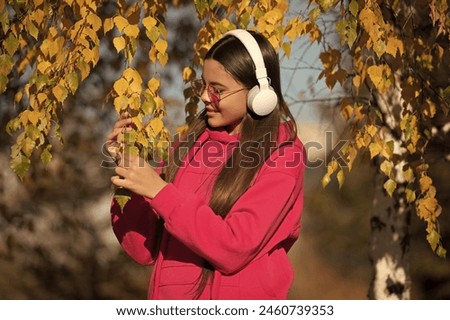 Happy adolescent girl on autumn walk listening music. Adolescent girl in fall style. girl in music headphones outdoor. Hello fall. autumnal fall colors. Adolescence concept. Groovy tunes