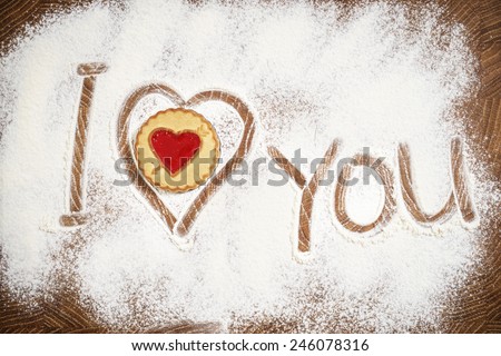 Heart and I Love You words of white flour on a wooden board. Cooking with love. Holiday backing background. Eco food and home cooking. 
