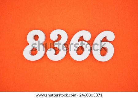 The number 8366 is made from white painted wood placed on a background of orange paper.