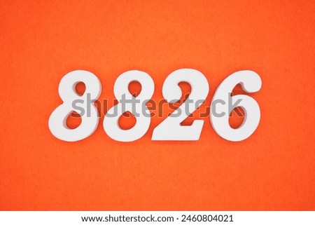 The number 8826 is made from white painted wood placed on a background of orange paper.