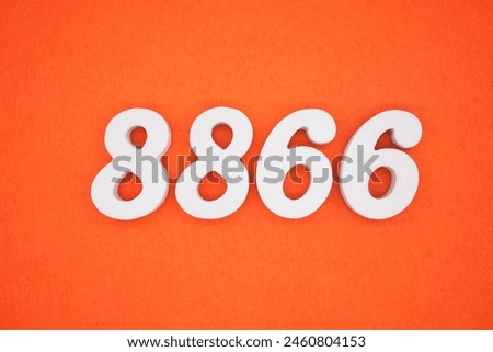 The number 8866 is made from white painted wood placed on a background of orange paper.