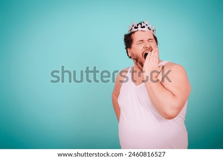 Funny football fan. Anger, joy and aggression. Fat man posing on a blue background.