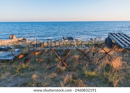 rusty anchors from fishing boats on the seashore against the background of the setting sun. fishing business