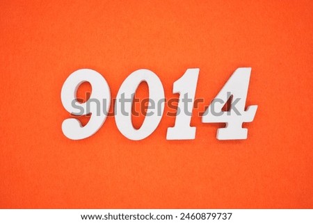 The number 9014 is made from white painted wood placed on a background of orange paper.