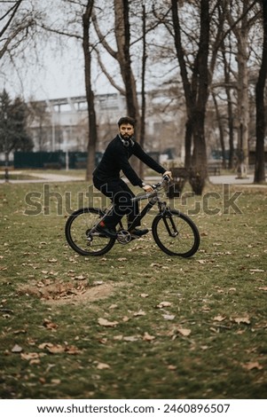 A focused businessman in casual attire taking a break to ride his bike in an urban park setting.