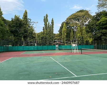 Two outdoor tennis courts in a city park setting