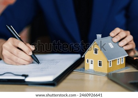 Interest and loan concept, woman is calculating house interest with documents
