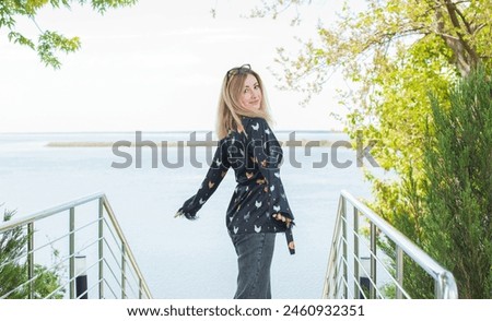 Pajama style in casual outfit. Woman wear silk blouse and jeans and chilling and resting outside