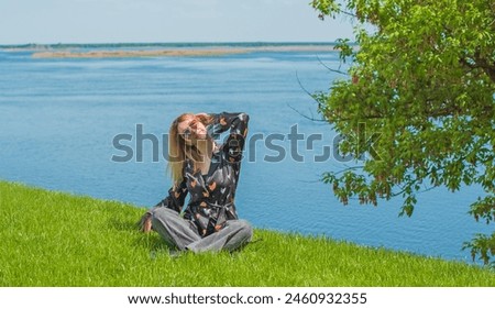 Pajama style in casual outfit. Woman wear silk blouse and jeans and chilling and resting outside