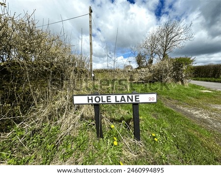 A street sign reading HOLE LANE stands prominently in the foreground, against a rural backdrop, high on the hill tops above, Silsden, Yorkshire, UK